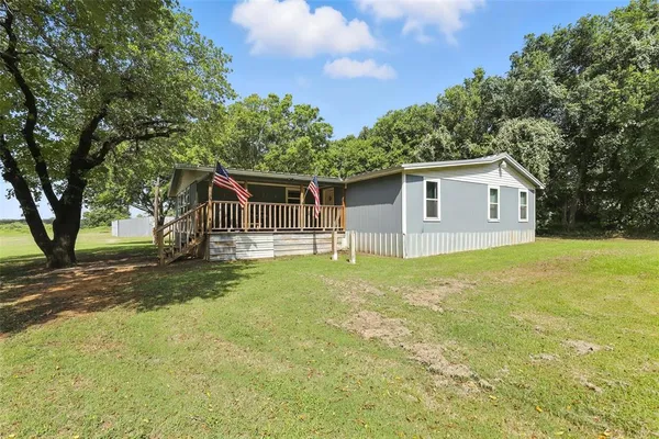 a front view of house with yard and trees
