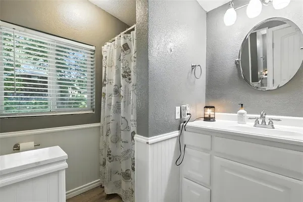 a bathroom with a sink a toilet and a mirror