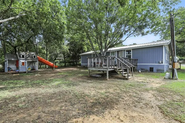 a view of a house with a yard patio and wooden fence