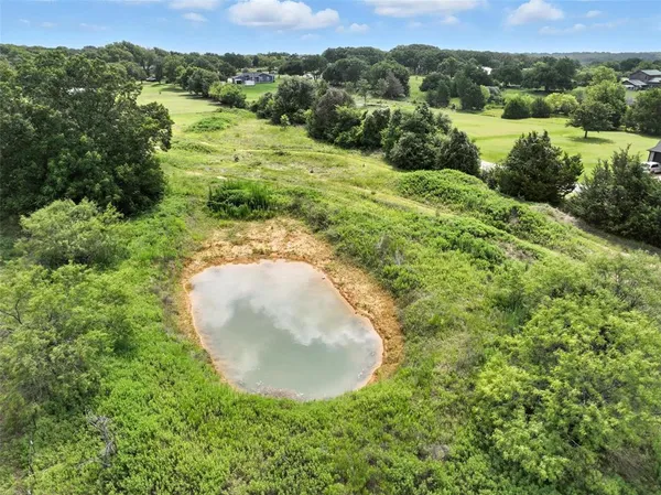 an aerial view of a house with a yard and trees