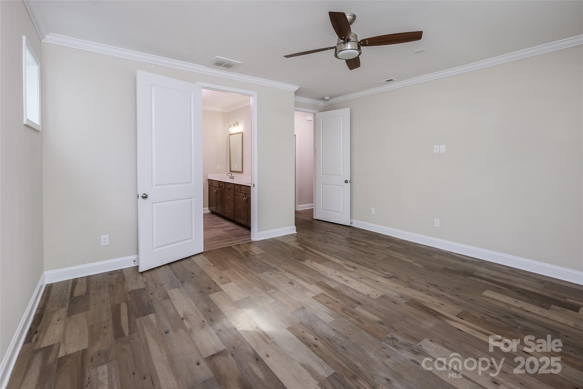 707 Marion Drive Matthews, NC 28105 - Photo 13 of 30 an empty room with wooden floor ceiling fan and windows