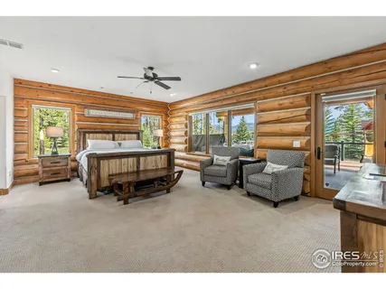 a bedroom with furniture and large windows