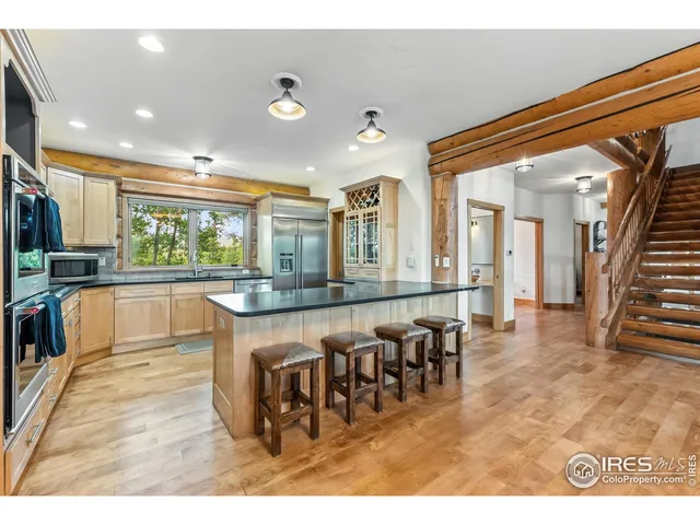 a living room with stainless steel appliances kitchen island granite countertop furniture and a large window