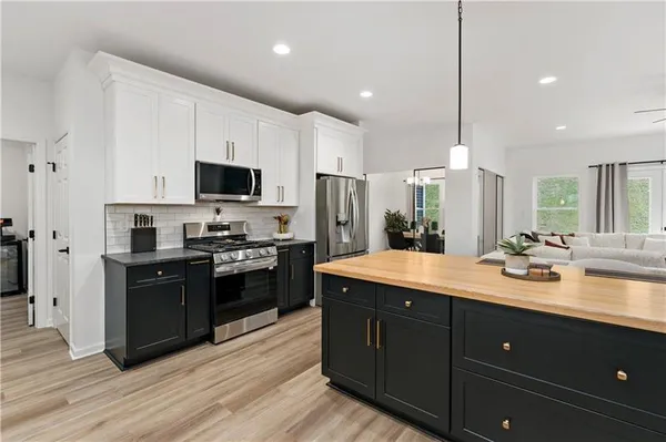 a kitchen with stainless steel appliances kitchen island granite countertop a stove a sink and a refrigerator