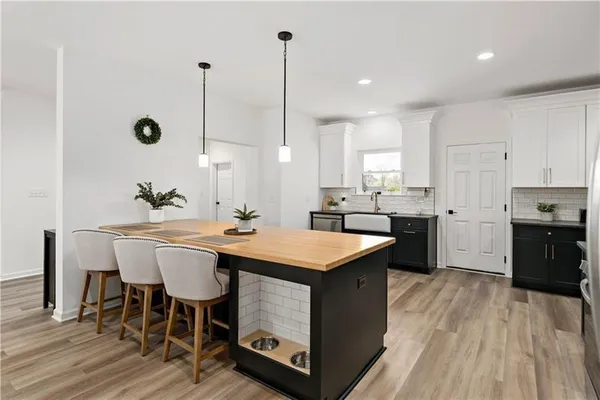 a kitchen with a sink a counter space dining table and stainless steel appliances