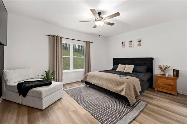 a bedroom with a large bed couch and a window