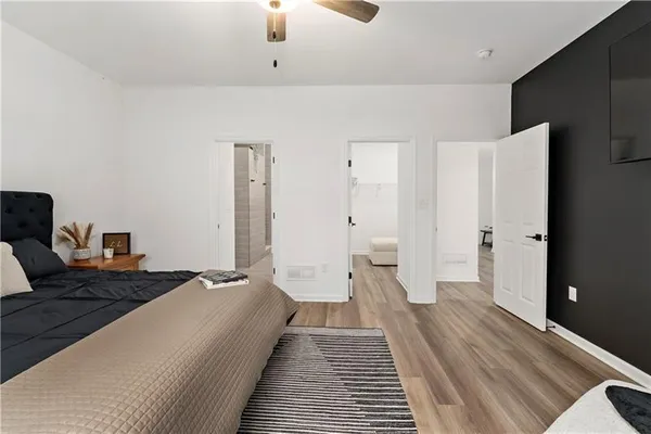 a spacious bedroom with a bed and wooden floor
