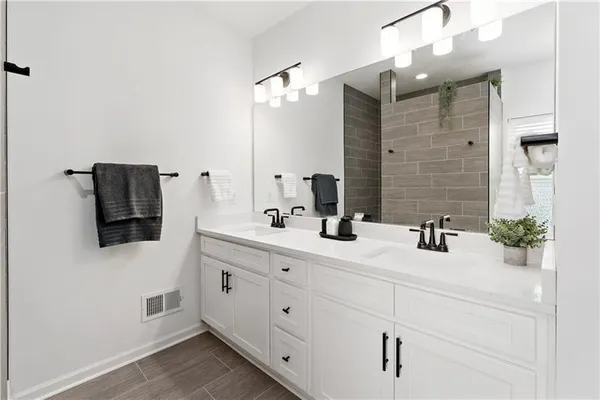 a bathroom with a double vanity sink and mirror