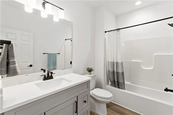 a bathroom with a sink a toilet a mirror and shower