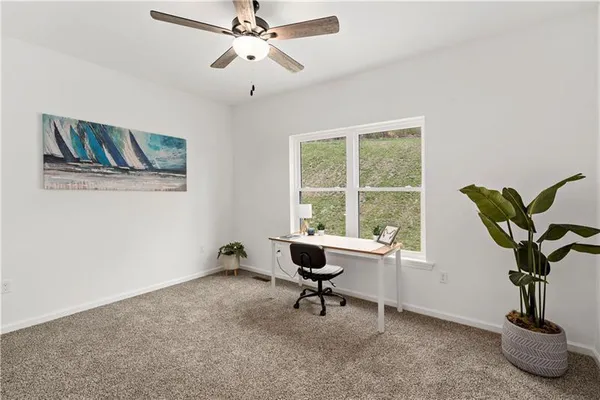 a view of a livingroom with workspace and a window