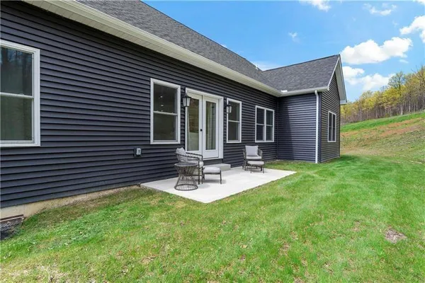 a view of a house with backyard and sitting area
