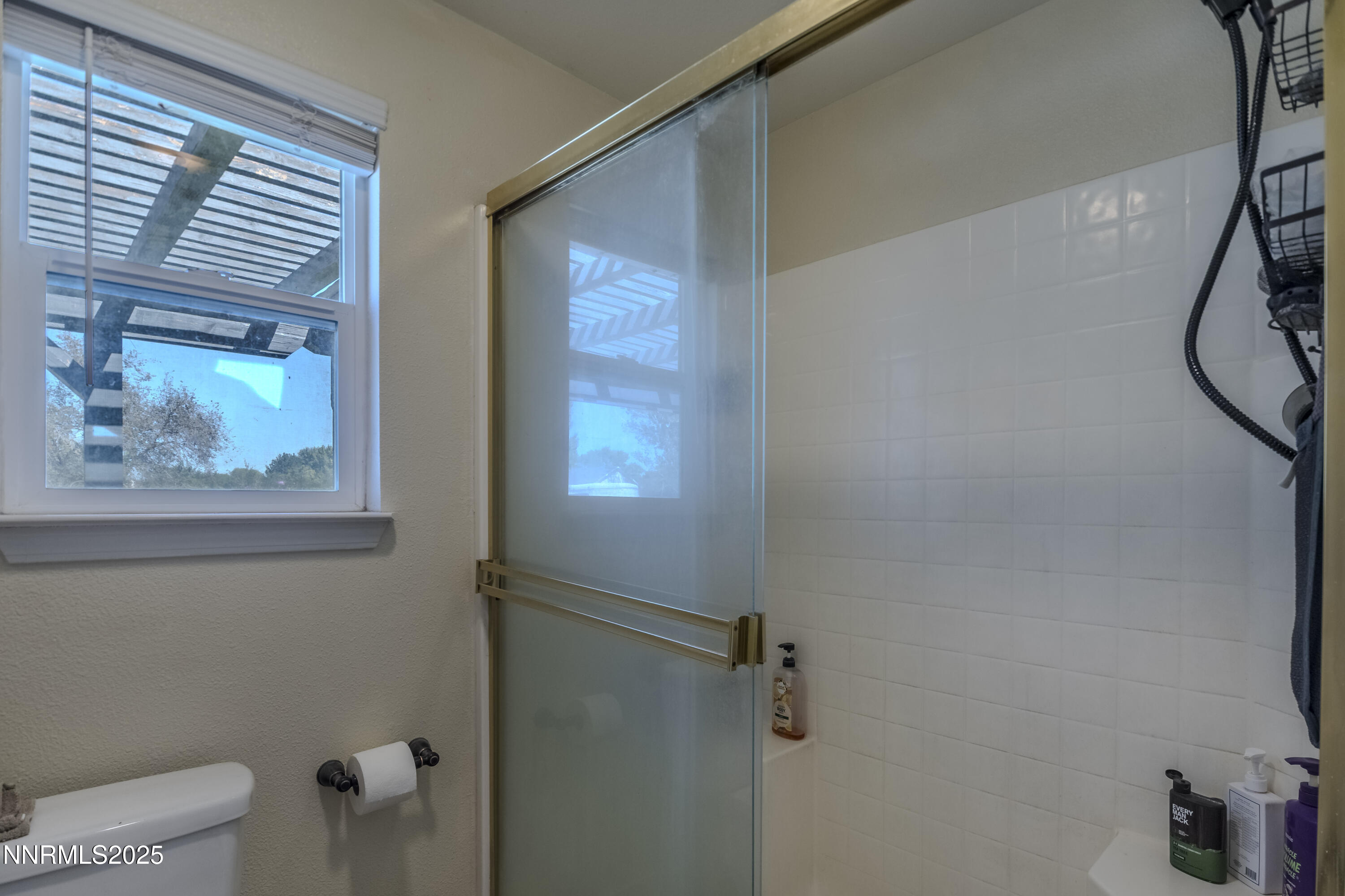 4190 Bottom Road Fallon, NV 89406 - Photo 17 of 44 a bathroom with a granite countertop sink a window and a shower