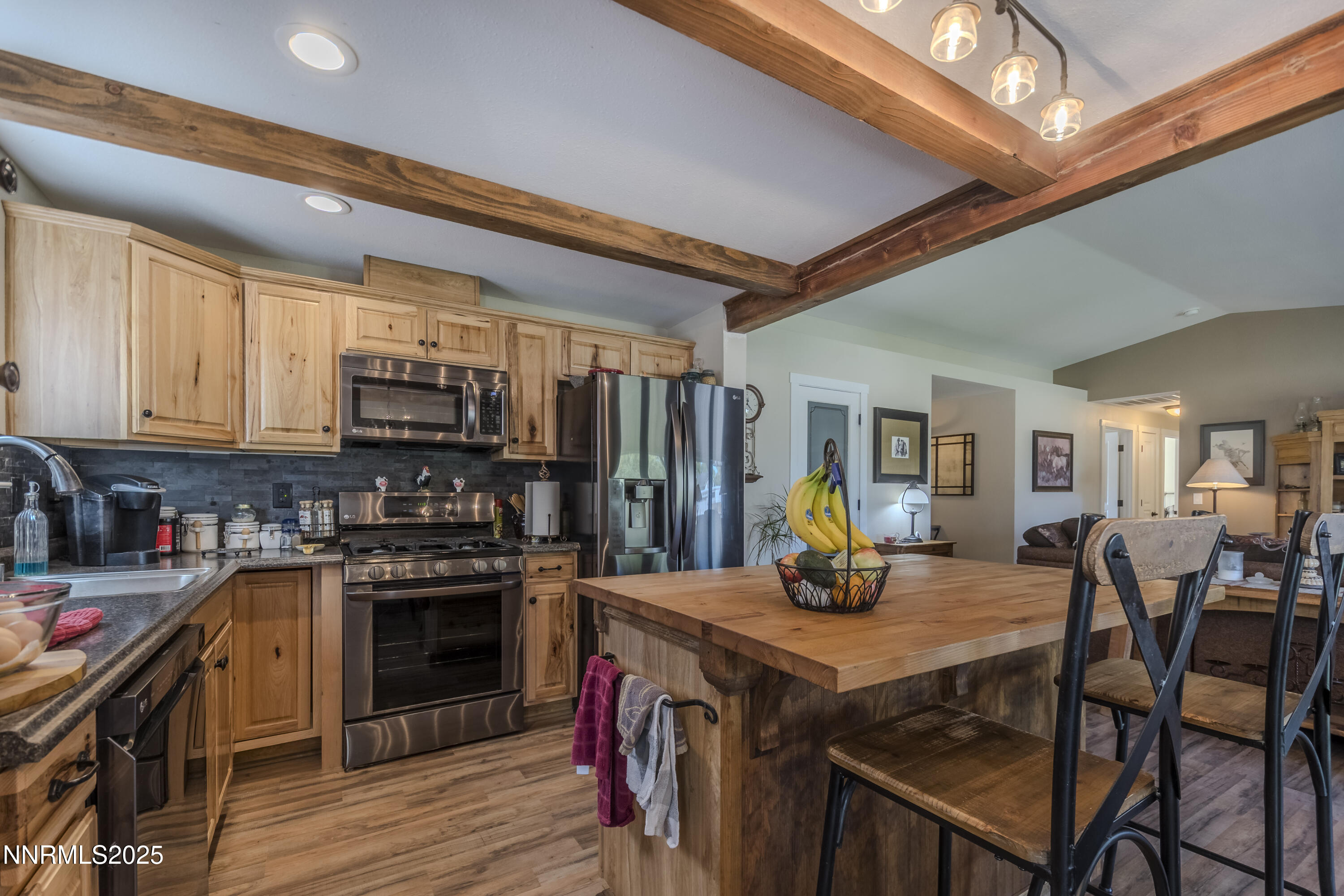 4190 Bottom Road Fallon, NV 89406 - Photo 9 of 44 a kitchen with stainless steel appliances granite countertop a stove top oven a refrigerator a dining table and chairs with wooden floor
