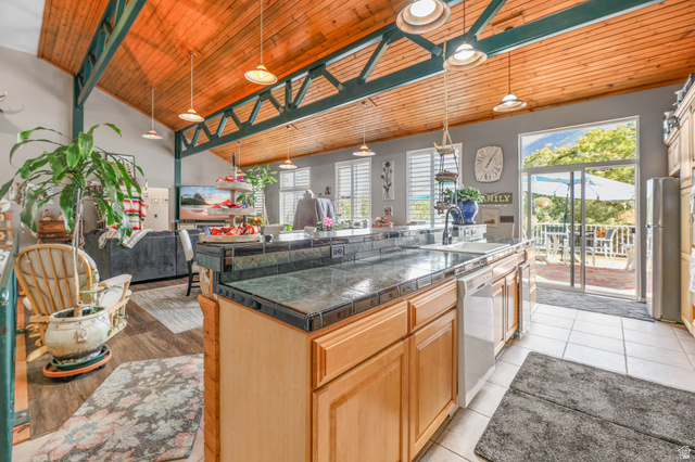 569 Elk Meadow Loop Tooele, UT 84074 - Photo 56 of 56 Kitchen with a center island with sink, open floor plan, a vaulted wood ceiling, dishwasher, and freestanding refrigerator