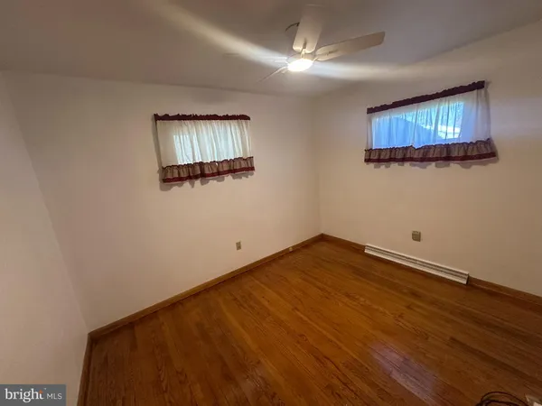 a view of a room with wooden floor and a ceiling fan