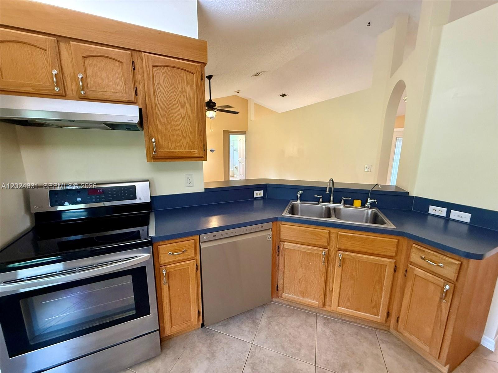 15819 76th Road North Loxahatchee, FL 33470 - Photo 17 of 45 a kitchen with stainless steel appliances a stove a sink and a microwave