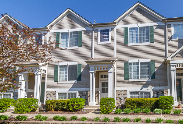 146 Enclave Circle, Unit D Bolingbrook, IL 60440 - Photo 1 of 33 a front view of a house with a yard and garage