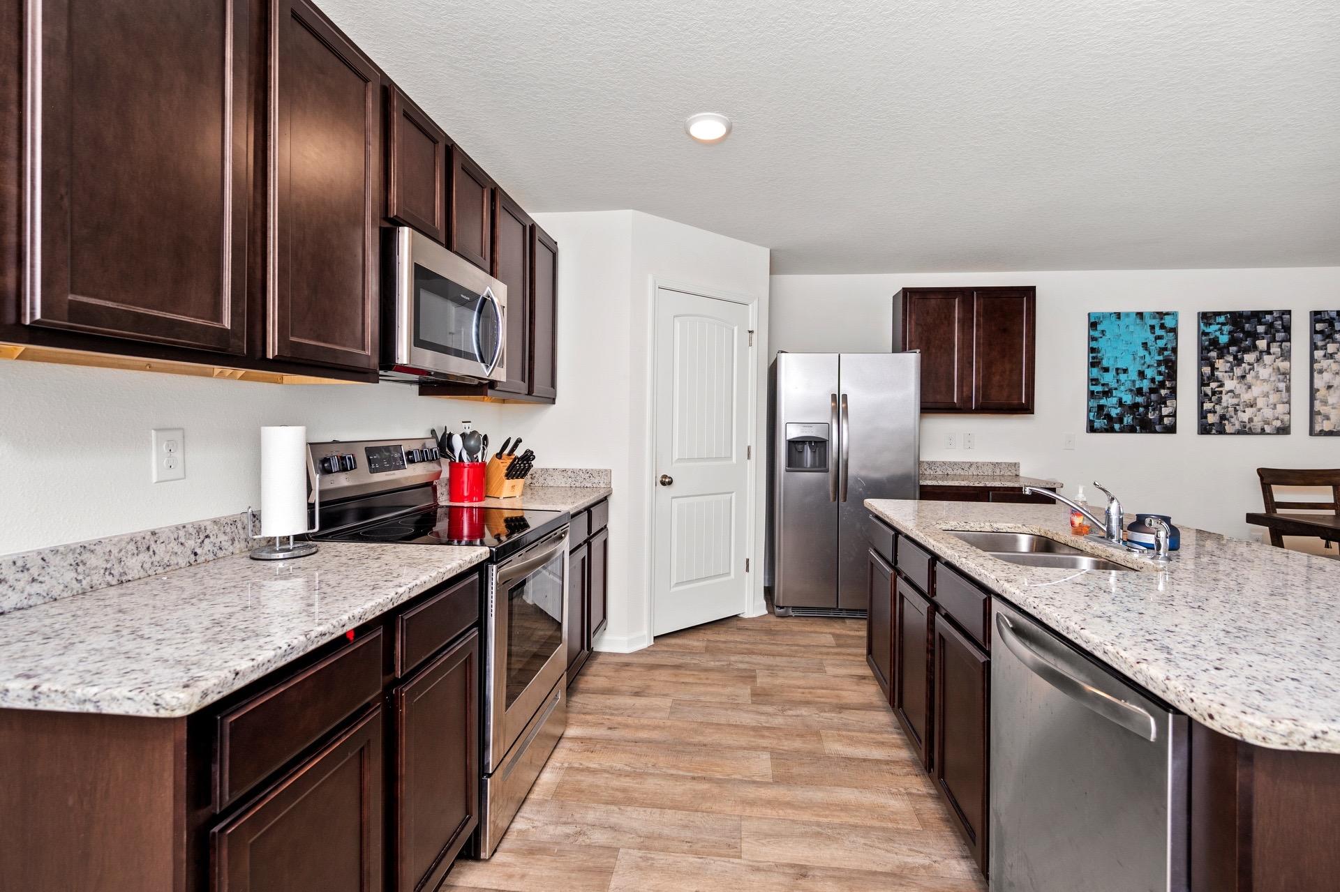 816 Moorhen Way Crestview, FL 32539 - Photo 11 of 22 a kitchen with stainless steel appliances granite countertop a kitchen island a stove a sink and a refrigerator