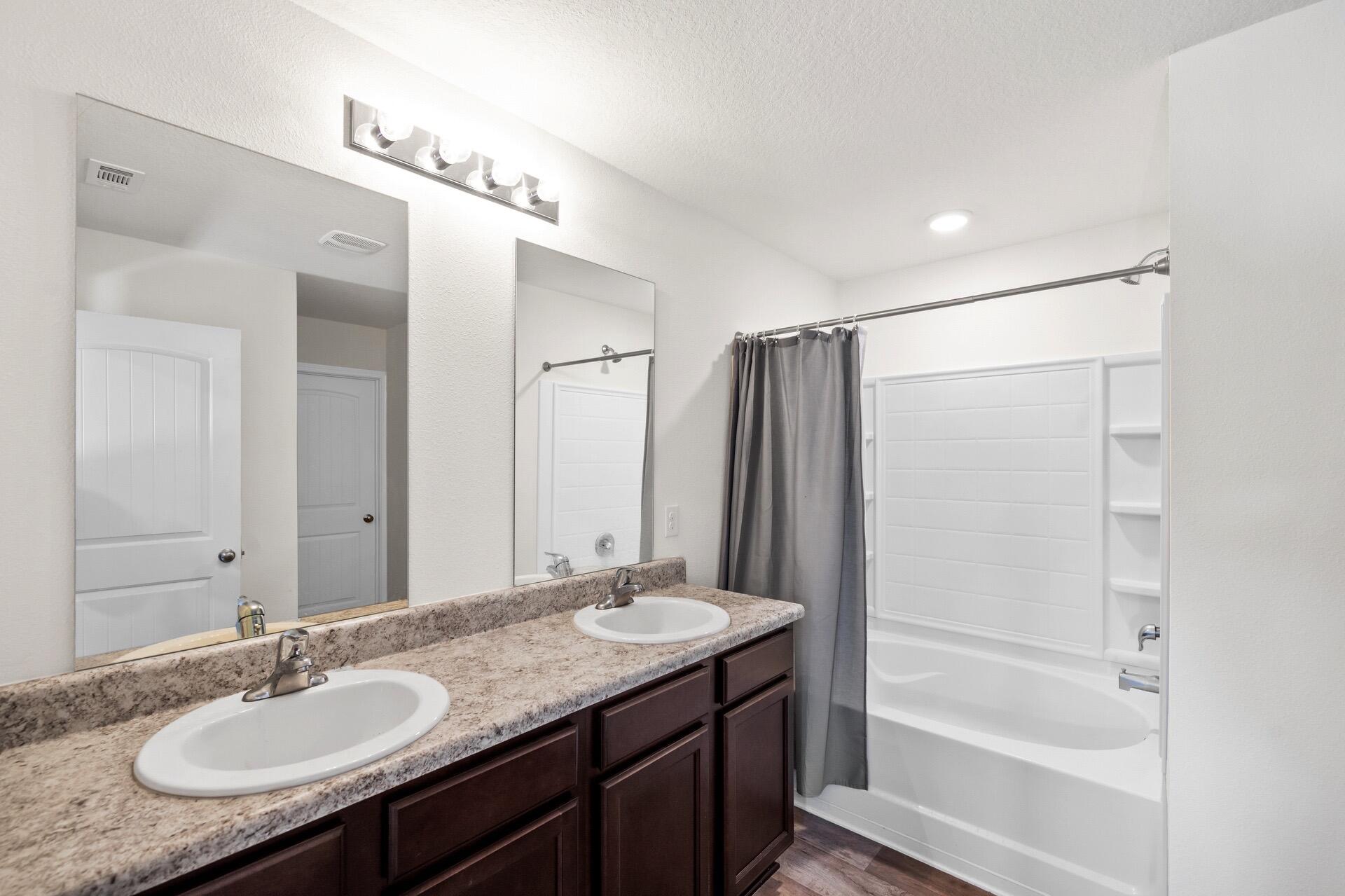 816 Moorhen Way Crestview, FL 32539 - Photo 17 of 22 a bathroom with a granite countertop sink mirror and a bathtub