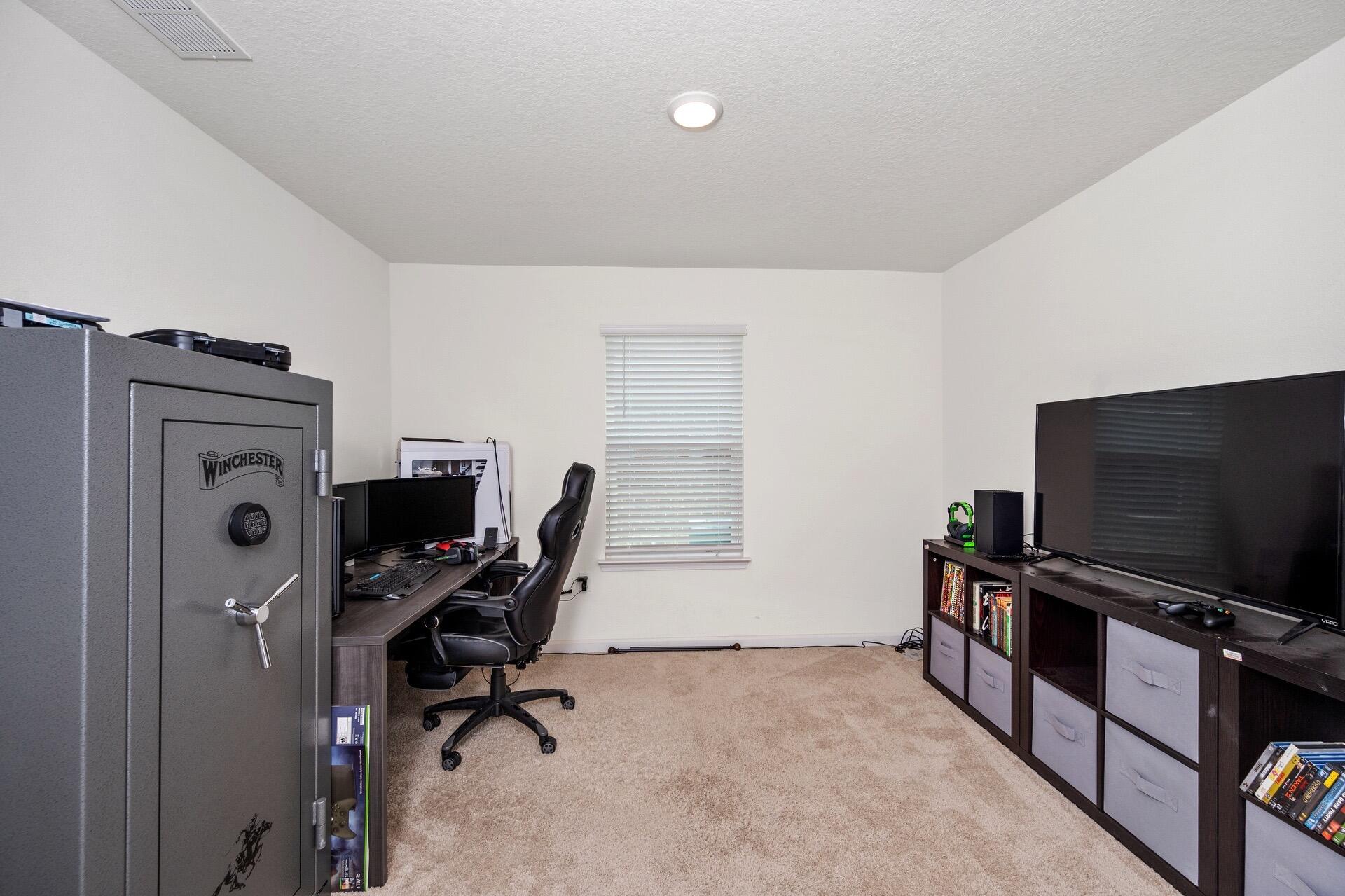 816 Moorhen Way Crestview, FL 32539 - Photo 18 of 22 a view of a workspace with furniture and a flat screen tv