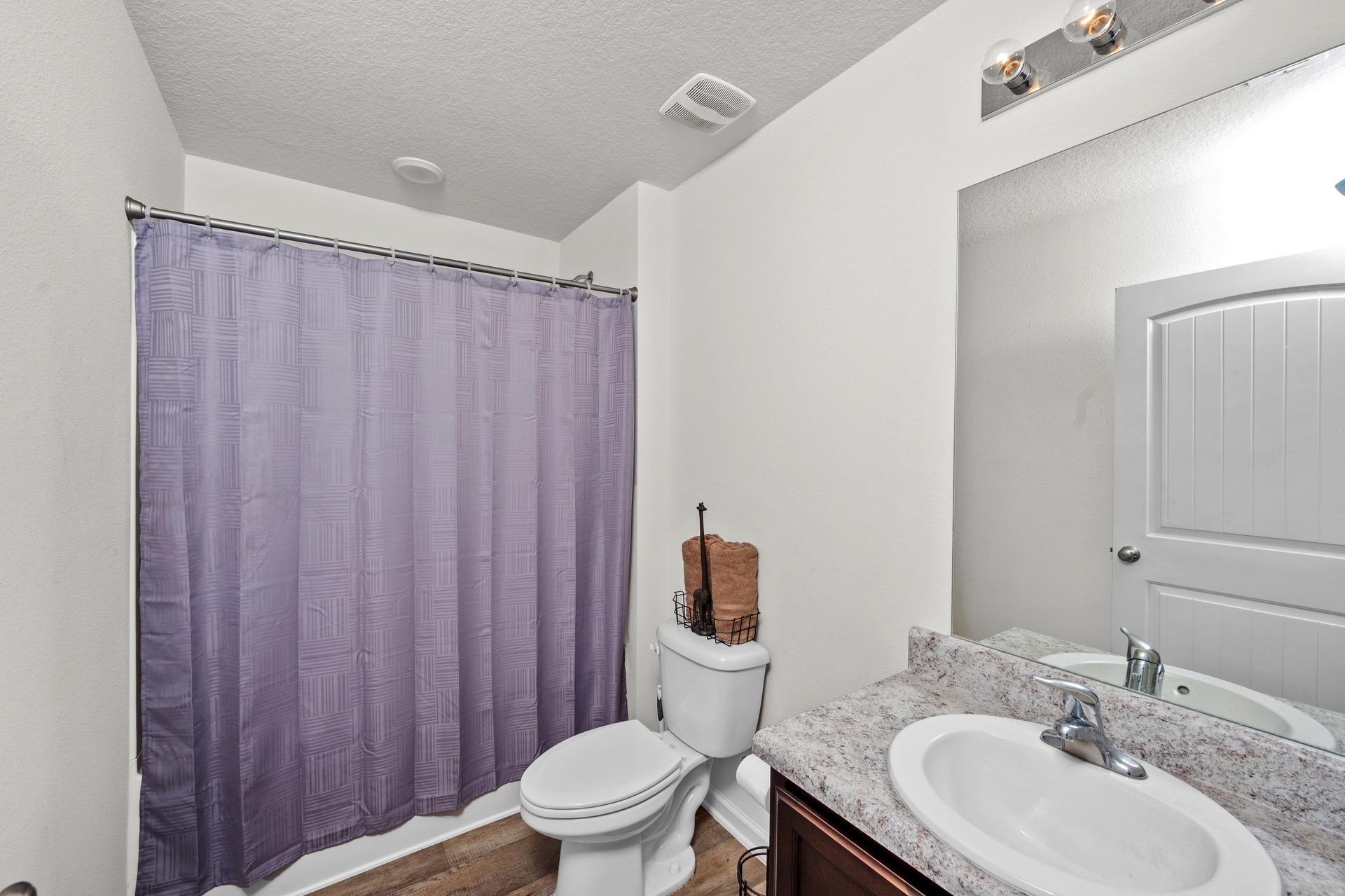 816 Moorhen Way Crestview, FL 32539 - Photo 20 of 22 a bathroom with a sink a toilet a mirror and shower curtain