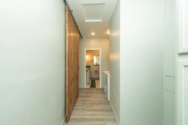 a view of a hallway with wooden floor and staircase