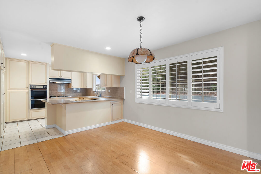 9631 Crystal View Drive Tujunga, CA 91042 - Photo 21 of 37 a open kitchen with white cabinets and wooden floor