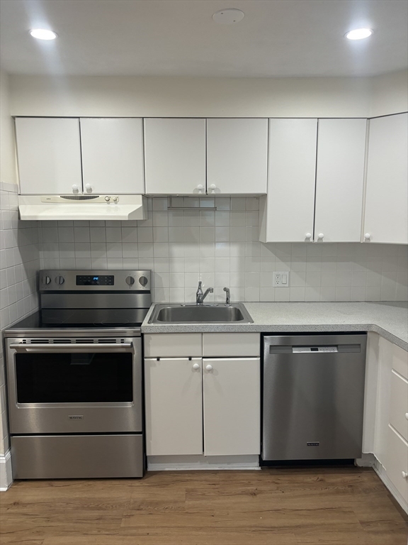 a kitchen with granite countertop white cabinets and a stove