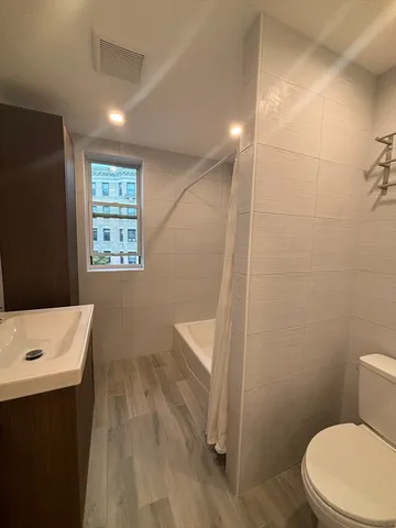 a bathroom with a sink a toilet and window