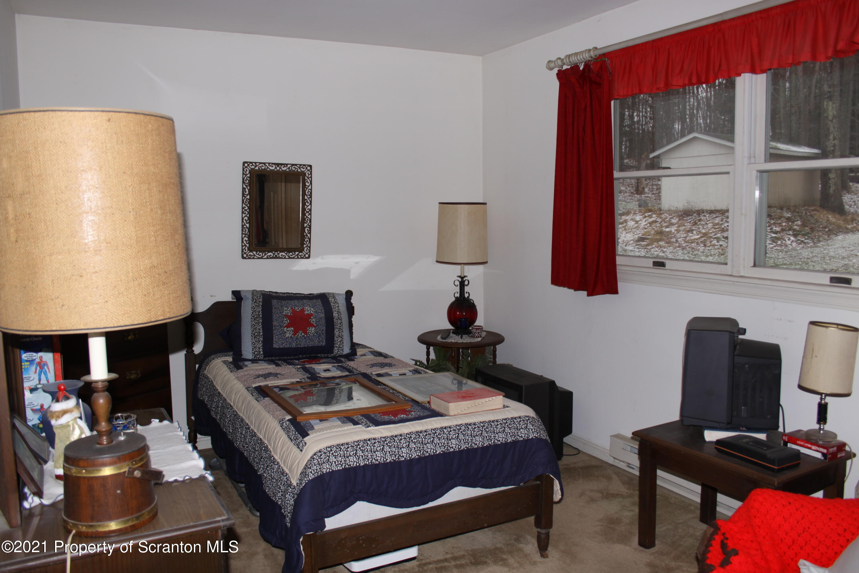 46 Cove Road Tunkhannock, PA 18657 - Photo 19 of 20 a bedroom with a bed a lamp on desk and a window