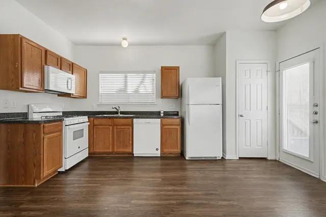 a kitchen with granite countertop white cabinets and white appliances