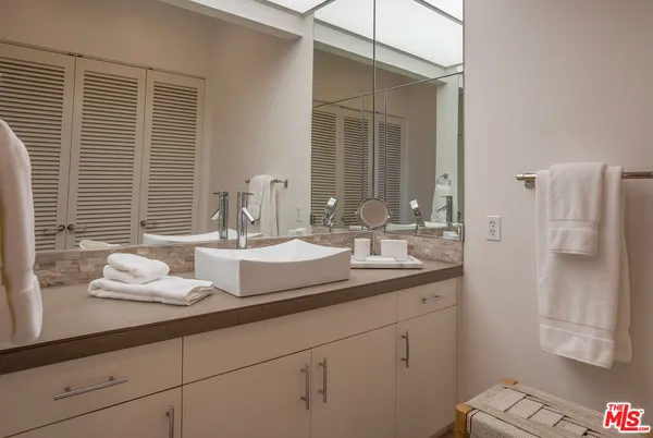 a bathroom with a granite countertop sink and a mirror