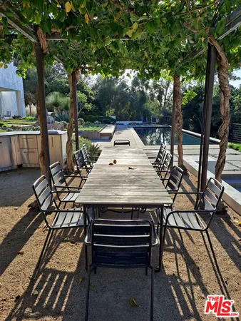 a view of a patio with table and chairs with wooden floor and fence
