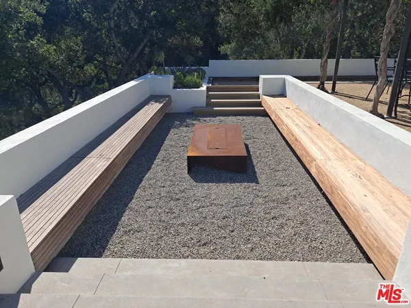 a view of deck with large trees and couches
