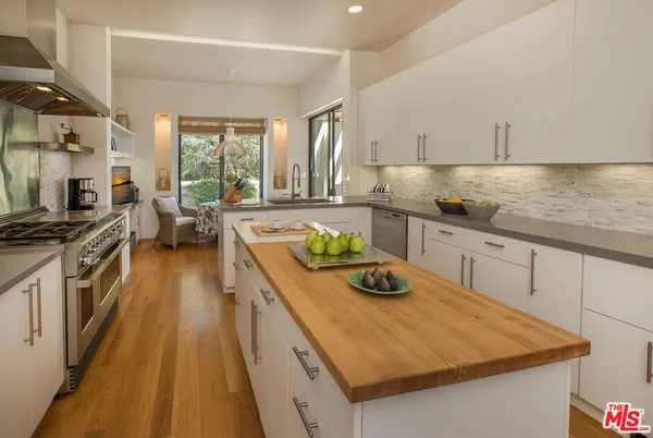 a kitchen with kitchen island white cabinets and stainless steel appliances