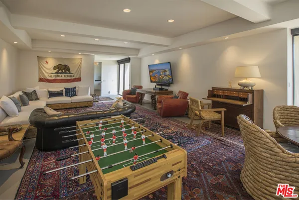 a living room with furniture a rug and a piano