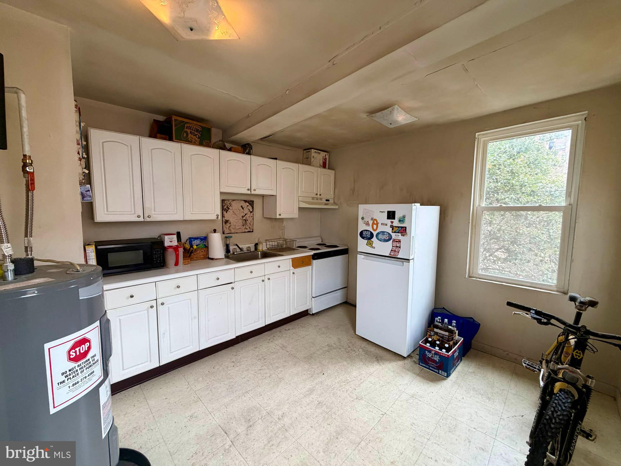1135 Light Street Baltimore, MD 21230 - Photo 17 of 41 a kitchen with a refrigerator a stove a sink and a window