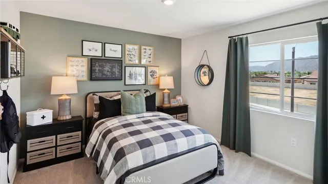 a bedroom with a bed and a flat tv screen on the dresser