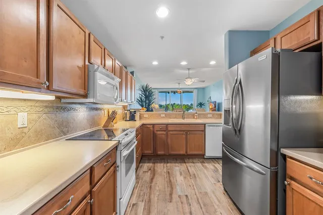 a kitchen with stainless steel appliances granite countertop a sink and a refrigerator