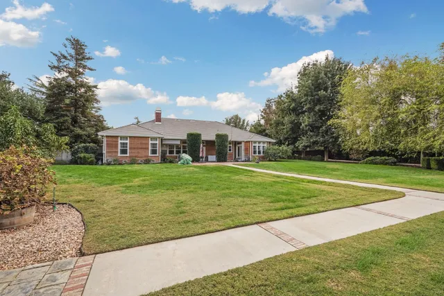 an aerial view of a house with a yard and tennis court