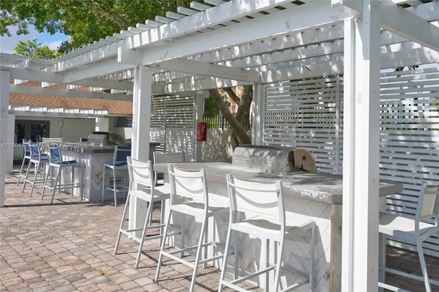 a dining room with furniture a chandelier and kitchen view