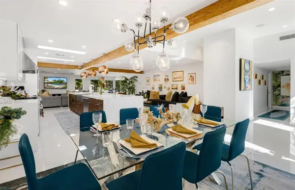 a view of a dining room with furniture a chandelier and wooden floor