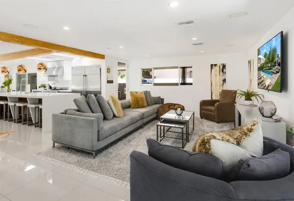 a living room with furniture a flat screen tv and a large window