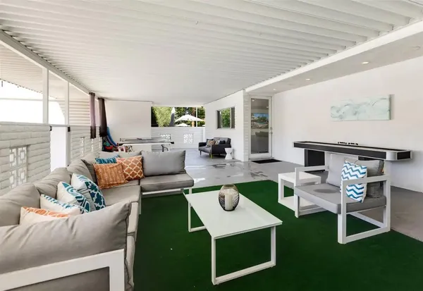 a view of a patio with table and chairs with wooden floor and fence