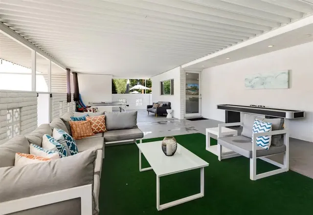 a view of a patio with table and chairs with wooden floor and fence