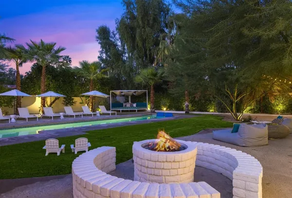 a front view of a house with garden and sitting area