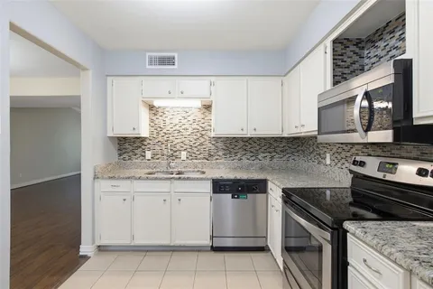 a kitchen with stainless steel appliances granite countertop a sink and a stove