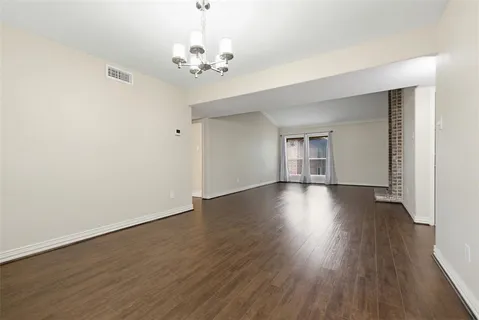 a view of empty room with wooden floor and window