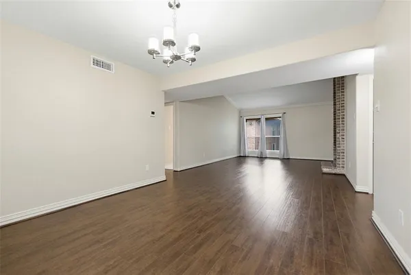 a view of empty room with wooden floor and window