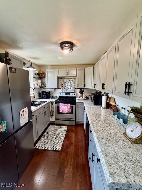 75 Ridgeland Drive Toronto, OH 43964 - Photo 9 of 18 Kitchen with stainless steel appliances, open shelves, dark wood-style flooring, and light stone countertops